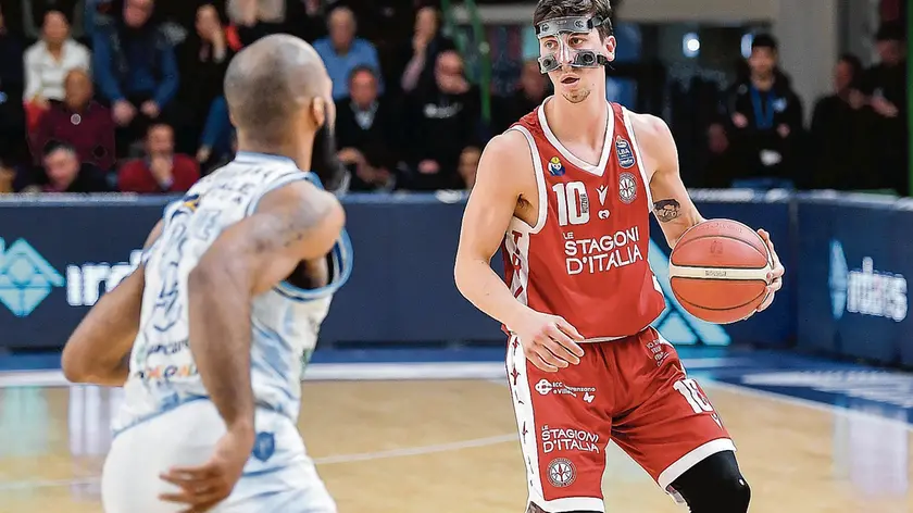 Nelle foto Ciamillo/Lasorte Michele Ruzzier in azione sul parquet di Sassari con la maschera protettiva usata in seguito alla frattura del naso rimediata contro Varese