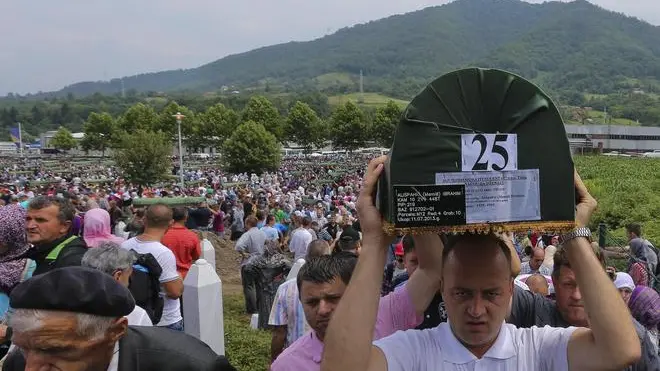 epa03784037 Bosnian men carry a coffin of one of the 409 newly-identified Bosnian Muslims at the Potocari Memorial Center in Srebrenica, Bosnia and Herzegovina, 11 July 2013, as part of a memorial ceremony to mark the 18th anniversary of the Srebrenica massacre, considered the worst atrocity of Bosnia's 1992-95 war. More than 8,000 Muslim men and boys were executed in the 1995 killing spree after Bosnian Serb forces overran the town. EPA/VALDRIN XHEMAJ