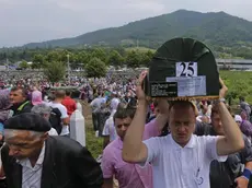 epa03784037 Bosnian men carry a coffin of one of the 409 newly-identified Bosnian Muslims at the Potocari Memorial Center in Srebrenica, Bosnia and Herzegovina, 11 July 2013, as part of a memorial ceremony to mark the 18th anniversary of the Srebrenica massacre, considered the worst atrocity of Bosnia's 1992-95 war. More than 8,000 Muslim men and boys were executed in the 1995 killing spree after Bosnian Serb forces overran the town. EPA/VALDRIN XHEMAJ