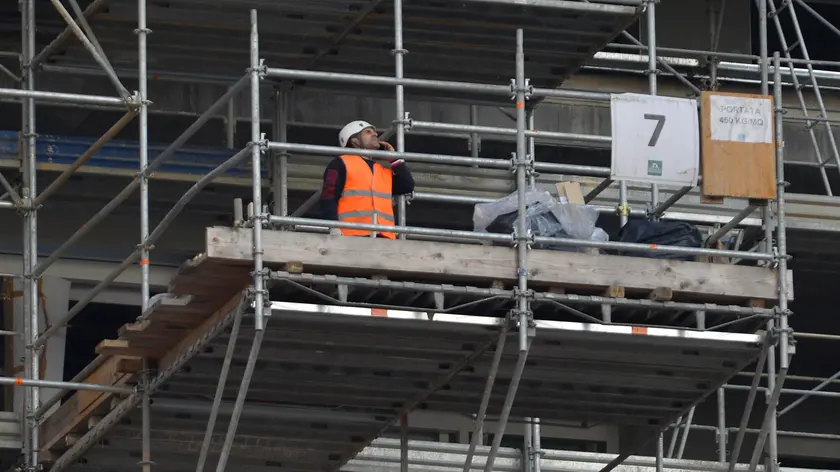 Un operaio al lavoro in un cantiere edile in una foto di repertorio