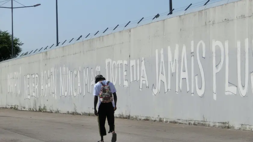 Un ospite del Cara davanti al muro del Cie, cento accoglienza immigrati