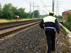 Un agente polfer lungo una linea ferroviaria