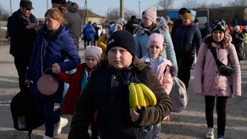 Refugees leaving to Romania after fleeing from Ukraine, walk at the border crossing in Palanca, Moldova, Thursday, March 17, 2022. (AP Photo/Sergei Grits)