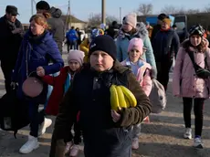 Refugees leaving to Romania after fleeing from Ukraine, walk at the border crossing in Palanca, Moldova, Thursday, March 17, 2022. (AP Photo/Sergei Grits)