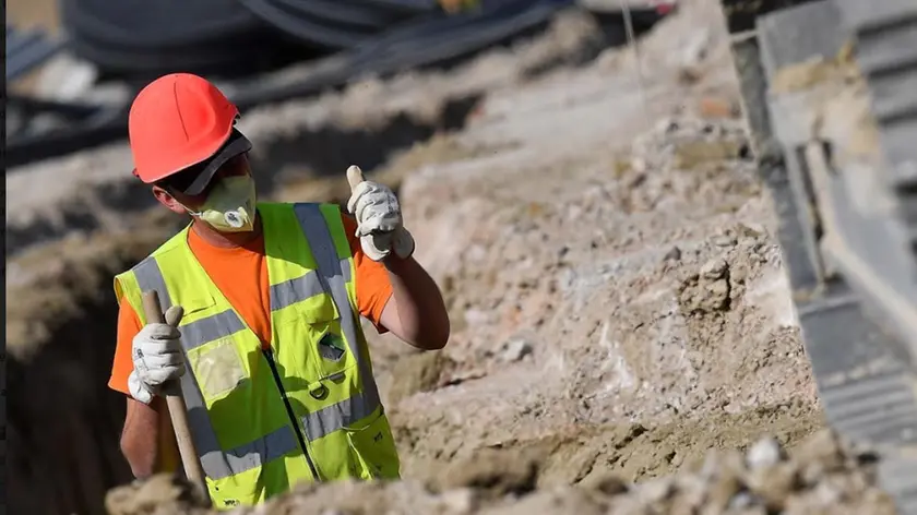 Un operaio al lavoro in un cantiere per la realizzazione della terza corsia