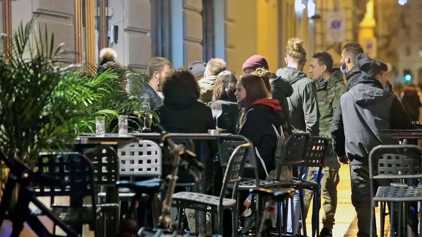 Persone al bar per l'aperitivo: da sabato non si potrà più consumare cibo e bevande in piedi dalle 15 (Silvano)