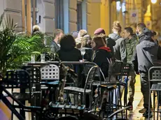Persone al bar per l'aperitivo: da sabato non si potrà più consumare cibo e bevande in piedi dalle 15 (Silvano)