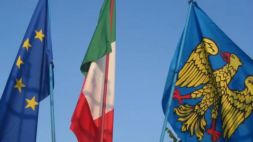 Una bandiera del Friuli issata vicino al Tricolore e alla bandiera europea