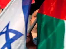 Israeli left wing activists hold Israeli and Palestinian flags to support the Palestinian U.N. bid for observer state status, during a rally in Tel Aviv, Israel, Thursday, Nov. 29, 2012. The Palestinians are certain to win U.N. recognition as a state on Thursday but success could exact a high price: delaying an independent state of Palestine because of Israel's vehement opposition. (AP Photo/Oded Balilty)