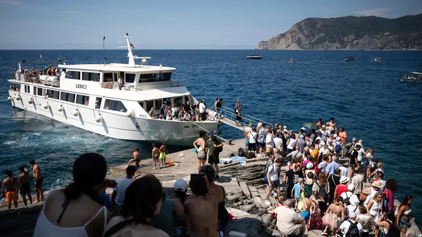 Turisti in attesa di salire a bordo di una barca turistica a Vernazza nel Parco Nazionale delle Cinque Terre