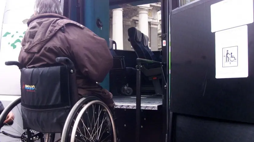 Un disabile mentre sale per mezzo della pedana su un bus in una foto d’archivio