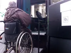 Un disabile mentre sale per mezzo della pedana su un bus in una foto d’archivio