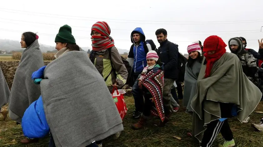 Refugees walk from Croatia to Slovenia through a green field near Rigonce village at the Slovenian border, 25 October 2015. .ANSA/ANTONIO BAT