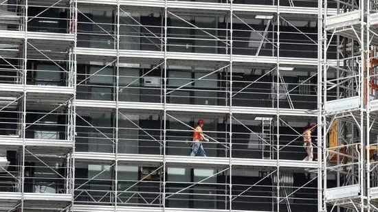 Operai al lavoro nel cantiere edile nella zona Porta Nuova a Milano. I quartieri Repubblica, Isola e Brera sono stati collegati con la posa di una passerella ciclopedonale che passa sopra via Melchiorre Gioia, 02 maggio 2013 a Milano. MATTEO BAZZI / ANSA