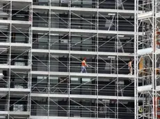 Operai al lavoro nel cantiere edile nella zona Porta Nuova a Milano. I quartieri Repubblica, Isola e Brera sono stati collegati con la posa di una passerella ciclopedonale che passa sopra via Melchiorre Gioia, 02 maggio 2013 a Milano. MATTEO BAZZI / ANSA