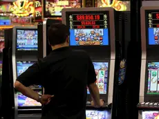 Un uomo gioca con una slot machine in una foto d'archivio. ANSA / YM YIK .