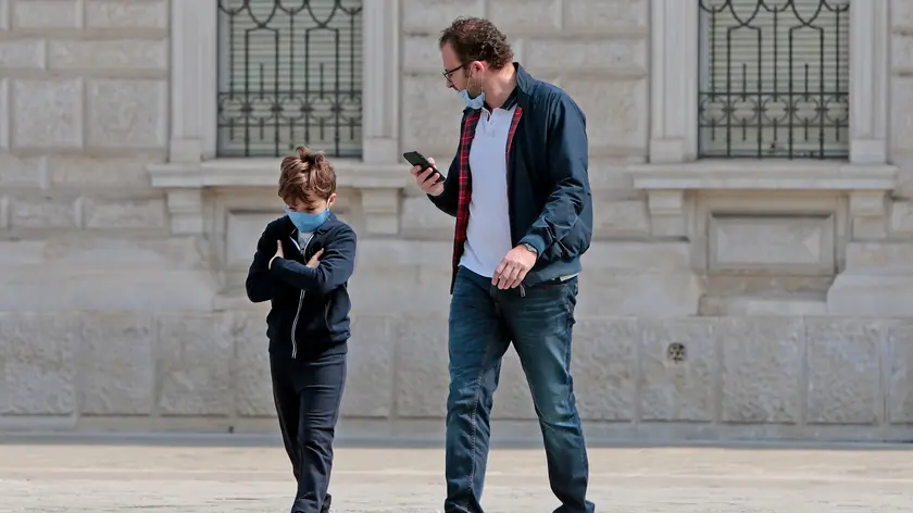 Papà e figlio a passeggio con le mascherine