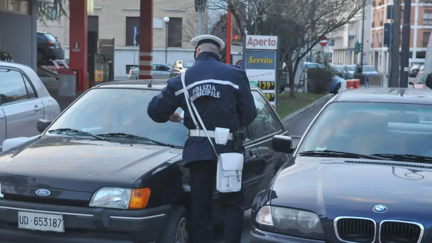 Un agente della polizia municipale intento a dare una multa (Foto di archivio)