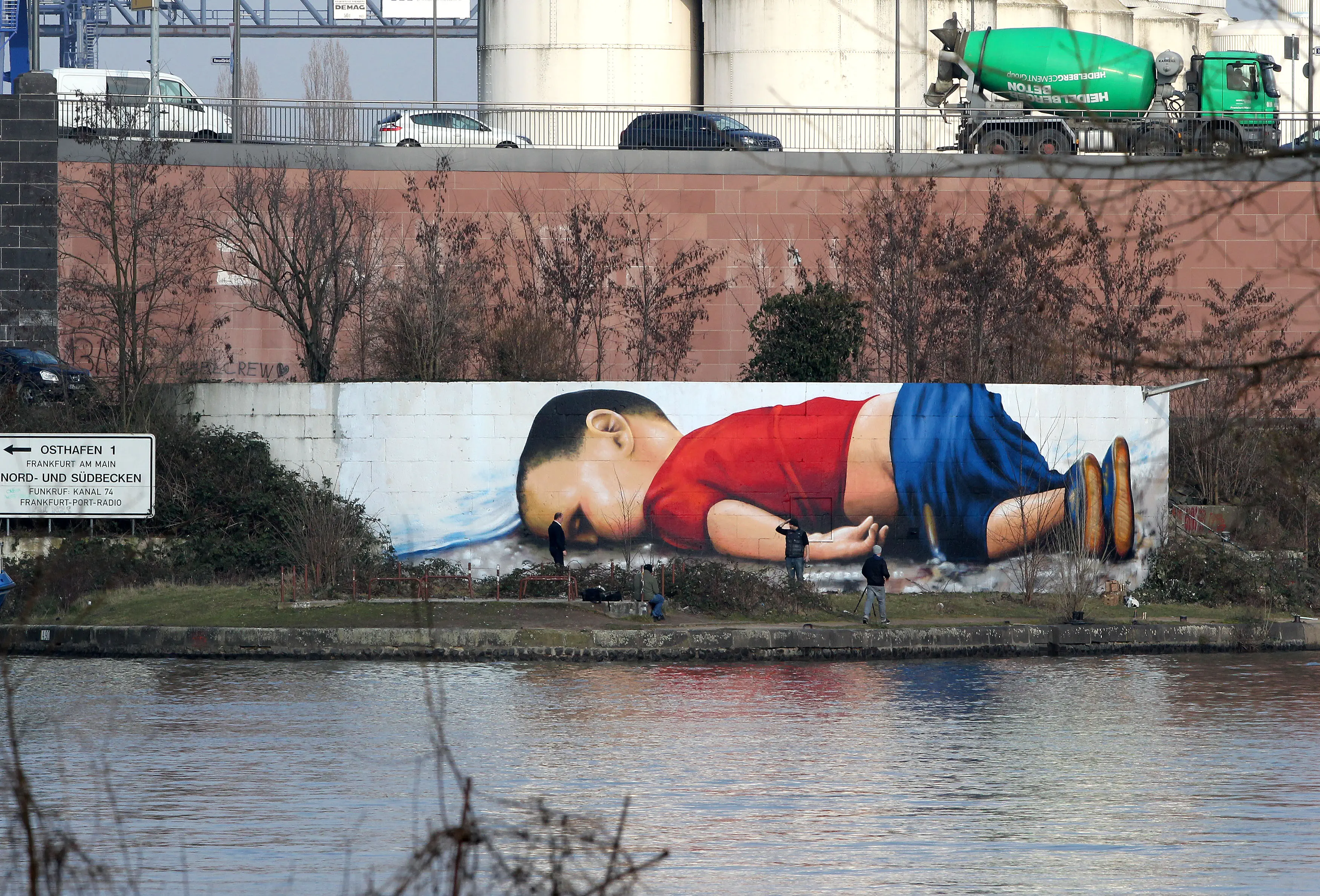 A graffiti by artists Justus Becker and Oguz Sen depicts the drowned Syrian refugee boy Alan Kurdi (initially reported as Aylan Kurdi) at the harbor in Frankfurt am Main, Germany, on March 10, 2016. / AFP / DANIEL ROLAND / RESTRICTED TO EDITORIAL USE - MANDATORY MENTION OF THE ARTIST UPON PUBLICATION - TO ILLUSTRATE THE EVENT AS SPECIFIED IN THE CAPTION (Photo credit should read DANIEL ROLAND/AFP via Getty Images)