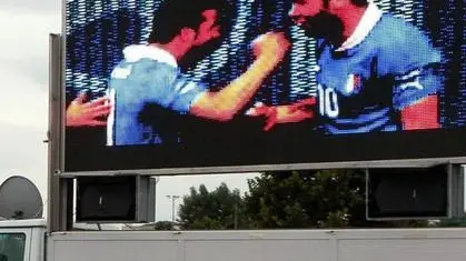 Gli ospiti delle tendopoli davanti al maxischermo per seguire la partita Italia-Spagna degli Europei di Calcio esultano dopo il gol di Di Natale a Medolla (Mo) in una foto d'archivio del 10 Giugno 2012. ANSA/ELISABETTA BARACCHI