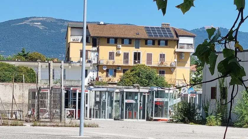 Il piazzale con le cabine dismesse. In alto la cabina telefonica di via Trieste e il telefono di corso Italia