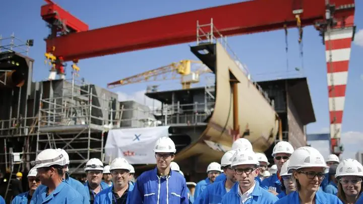 FILE - In this Wednesday, May 31, 2017 file photo, STX workers gather at the STX shipyard site in Saint-Nazaire, western France. The French and Italian governments are confident a deal will be announced Wednesday Sept.27 2017 allowing Italian shipbuilder Fincantieri to take control of a key French shipyard, ending a weeks-long disagreement between the countries. (Stephane Mahe/Pool Photo via AP, File)
