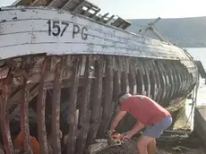 Il pescatore Fabijanić mentre sega il suo peschereccio