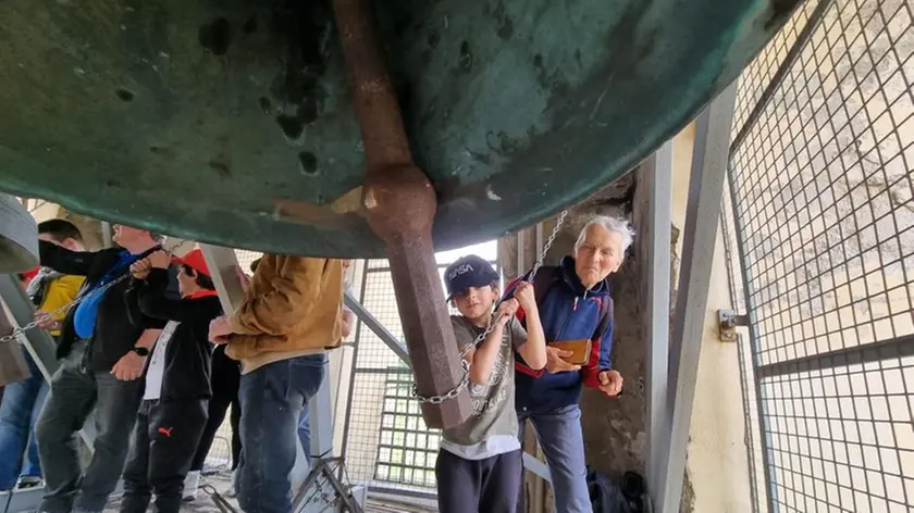 Un bambino suona una campana del duomo di Cormons
