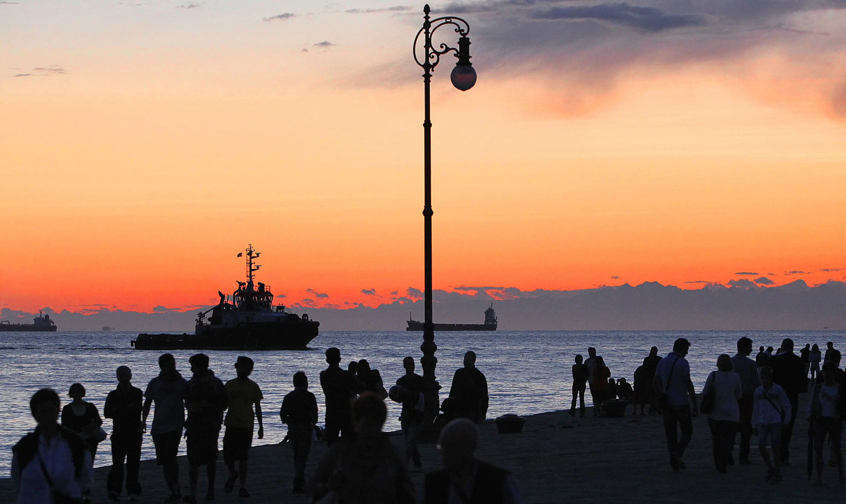 Una suggestiva immagine di Andrea Lasorte:il tramonto visto dal molo Audace. Sullo sfondo, un rimorchiatore