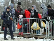 epa05109208 An armed official stands guard as migrants from Syria, Iraq and Afghanistan walk in very cold weather, through snow from Macedonia to a camp for the temporary acceptance of migrants in the village Miratovac, on the border between Serbia and Macedonia, near to the south Serbian city of Presevo, 18 January 2016. Since the second half of November 2015, countries further along the Balkan route - Macedonia, Serbia, Croatia, Slovenia and Austria have stopped all so-called economic migrants and are allowing only Syrians, Afghans and Iraqis to pass. EPA/DJORDJE SAVIC