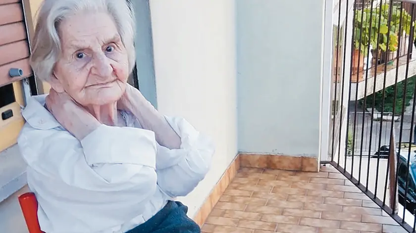 La signora Gisella seduta sul balconcino della sua abitazione