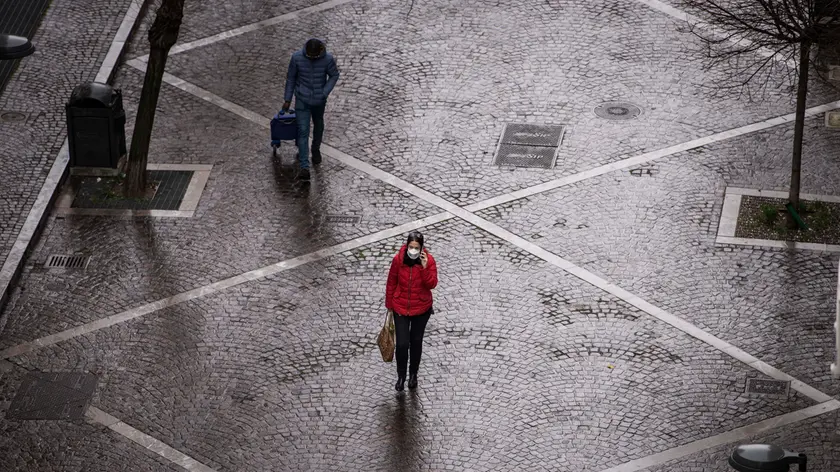 A woman wearing a surgical mask walks in an empty street in Trieste. To contain the spread of the coronavirus, as the death toll continues to rise, Italy has implemented drastic measures throughout the whole country. All non essential commercial activities as well as school, universities, theatres and cinemas have been shut down and people are urged to stay at home. Trieste, 13th of march 2020. (Photo by Jacopo Landi/NurPhoto via Getty Images)