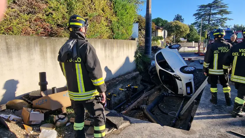 L'auto finita dentro lo scavo del cantiere domenica mattina a Pieris. Foto Bonavenura