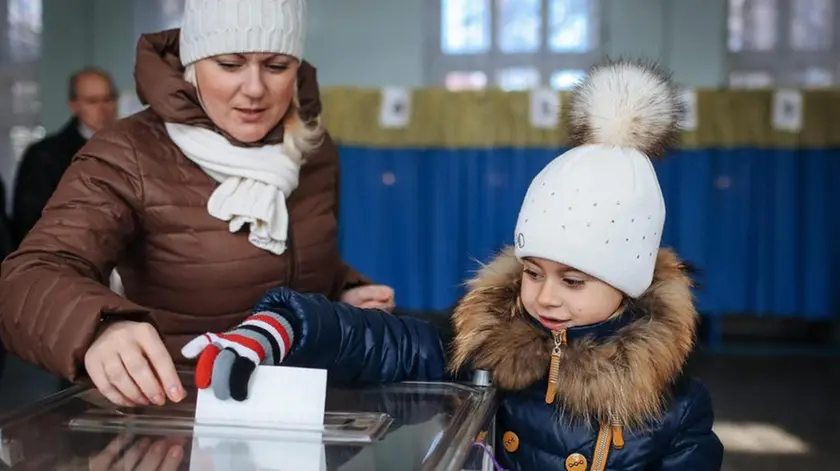 Una bambina accompagna la mamma al seggio per le elezioni in Ucraina