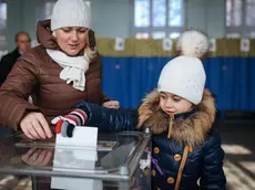 Una bambina accompagna la mamma al seggio per le elezioni in Ucraina