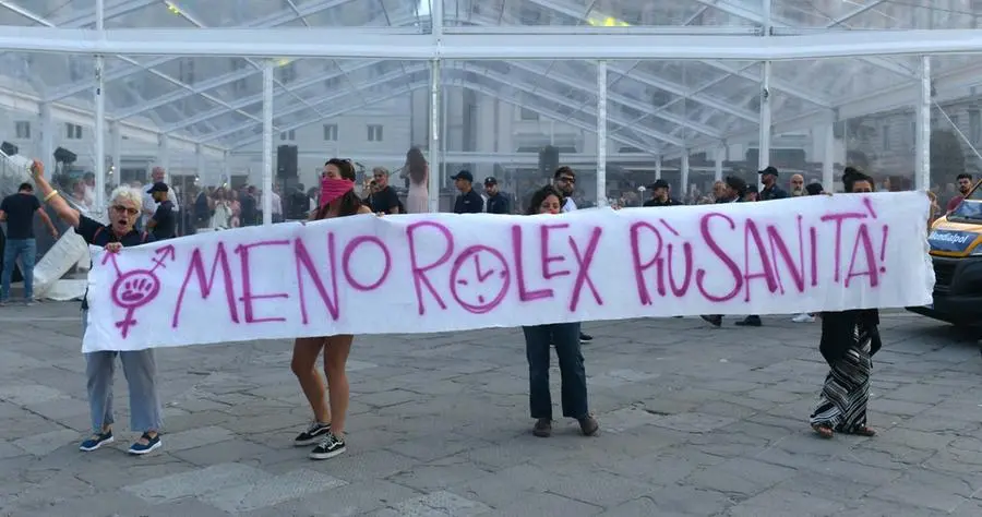 Il riferimento è all'iniziativa organizzata in piazza Unità sempre la sera del 28: nella tensostruttura alle spalle dei manifestanti si è tenuta una cena di gala per appassionati degli orologi di marca. Foto Bruni