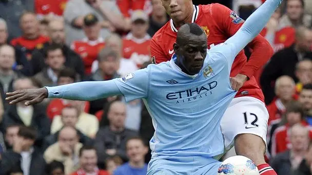 epa02977964 Manchester United's Chris Smalling (rear) challenges Manchester City's Mario Balotelli during the English Premier League soccer match between Manchester United and Manchester City at Old Trafford, Manchester, Britain, 23 October 2011. EPA/ROGER PARKER DataCo terms and conditions apply http//www.epa.eu/downloads/DataCo-TCs.pdf