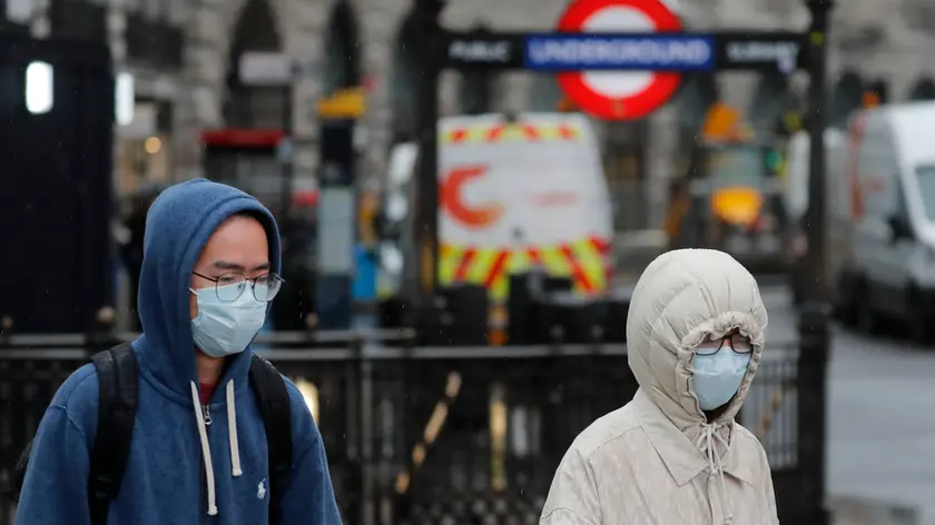 Pedestrians wear face masks as they walk at Piccadilly Circus main tourist destination in central London, as the public are asked to take precautions to protect themselves from the COVID-19 Coronavirus outbreak, Thursday, March 5, 2020.(AP Photo/Frank Augstein)