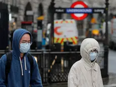 Pedestrians wear face masks as they walk at Piccadilly Circus main tourist destination in central London, as the public are asked to take precautions to protect themselves from the COVID-19 Coronavirus outbreak, Thursday, March 5, 2020.(AP Photo/Frank Augstein)