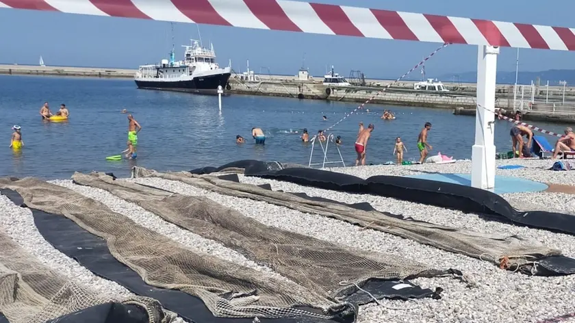 Le panne stese sulla spiaggia della parte maschile del Pedocin. Oggi si tenterà di metterle in acqua