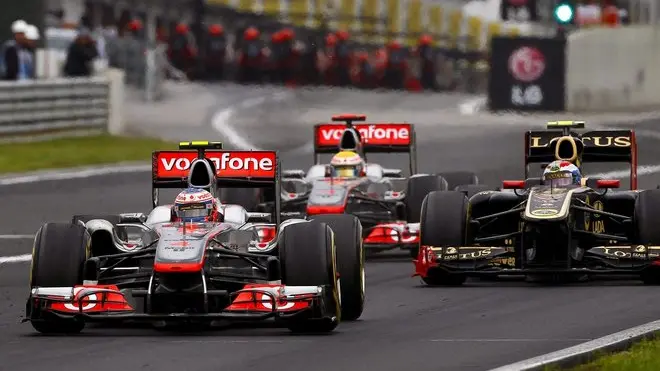 epa02850347 British Formula One driver Jenson Button (front) of McLaren Mercedes is followed by his teammate Lewis Hamilton (C) and Russian Vitaly Petrov (R) of Lotus Renault GP on his way to win the Formula Grand Prix of Hungary at the Hungaroring race track in Mogyorod, near Budapest, Hungary, 31 July 2011. EPA/VALDRIN XHEMAJ
