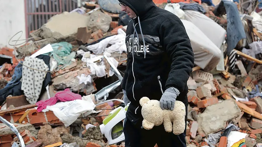 A man searches through the rubble of collapsed houses in Majska Poljana, Croatia, Wednesday, Dec. 30, 2020. A series of tremors have jolted central Croatia a day after a 6.3-magnitude earthquake killed at least seven people, injured dozens and left several towns and villages in ruins. (AP Photo)