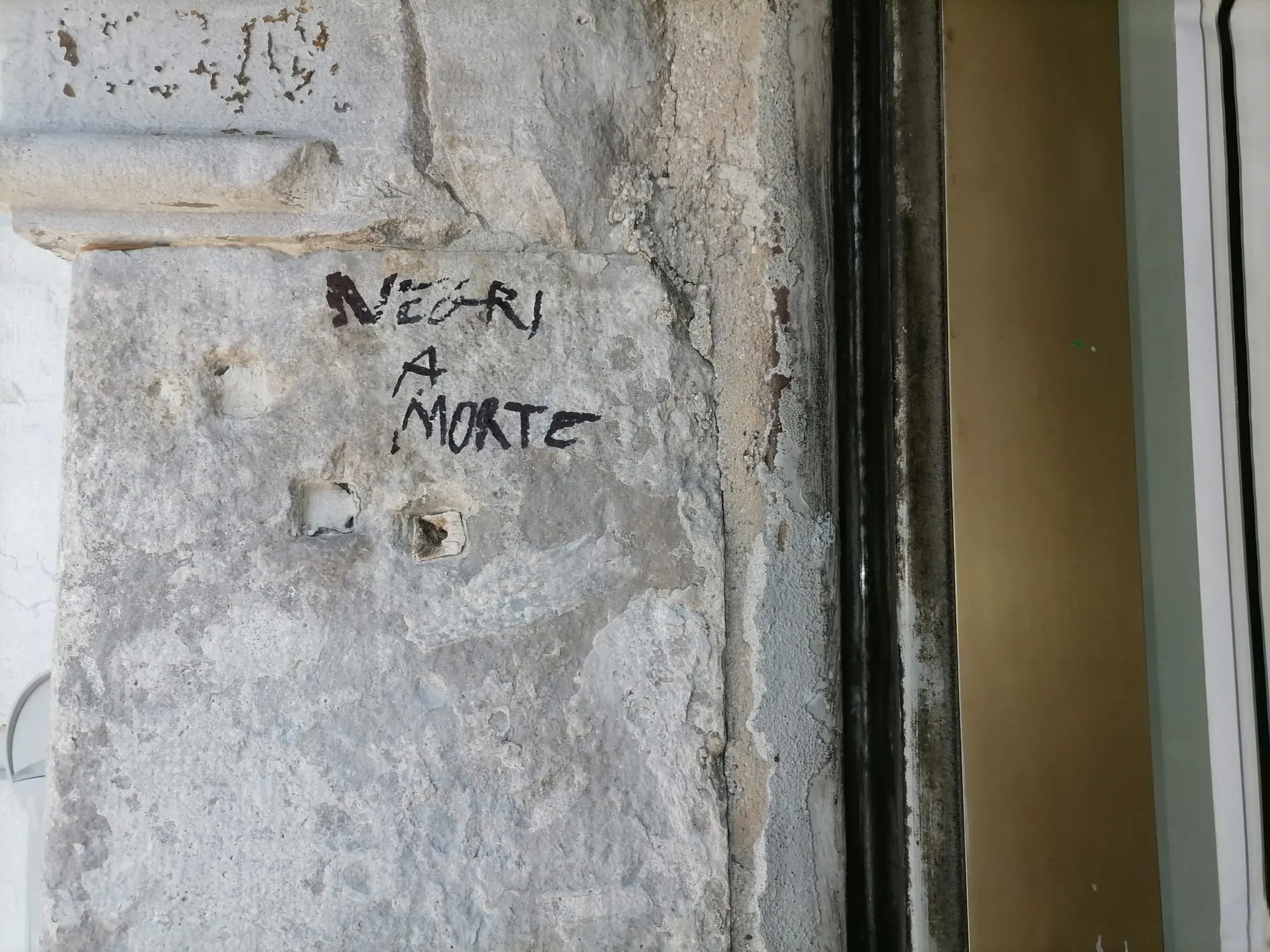 Una delle scritte minatorie apparse sul muro del Centro Luchetta