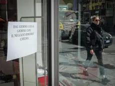 Un cartello esposto su una porta vetrata di un negozio di corso Buenos Aires informa il pubblico della momentanea chiusura dell'esercizio a causa dell'emergenza coronavirus, Milano, 11 marco 2020. In Corso Buenos Aires, un' importante strada commerciale di Milano, che si estendo su oltre 1600 metri con oltre 350 punti vendita di vari tipi di merce e una media di centomila persone ogni giorno, questa mattina metà dei negozi erano chiusi. ANSA/MATTEO CORNER