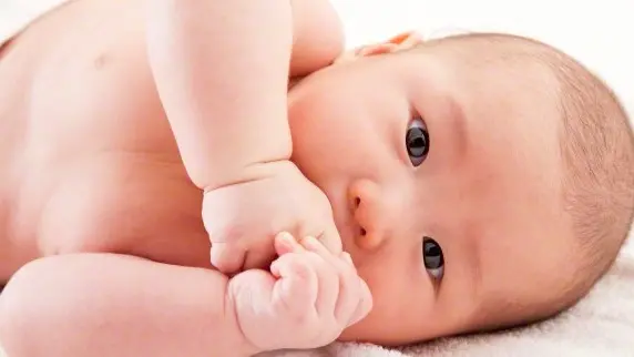 24 Dec 2014 --- Baby boy lying down on side and looking at the camera --- Image by © IMAGEMORE M/Imagemore Co., Ltd./Corbis