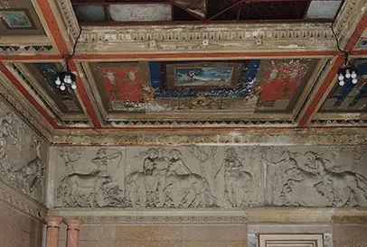 Il soffitto riccamente decorato di una delle sale di palazzo Artelli