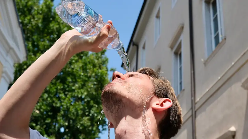 Un giovane si rinfresca la testa. Foto Silvano