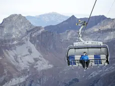 A skier wearing a medical face mask takes the 'Ice Flyer' chairlift on the Titlis, 10 November 2020, in Switzerland (issued 11 November 2020). Masks must be worn on all chairlifts, ski lifts and cableways in the ski area at times of Covid-19, Coronavirus pandemic. ANSA/ALEXANDRA WEY