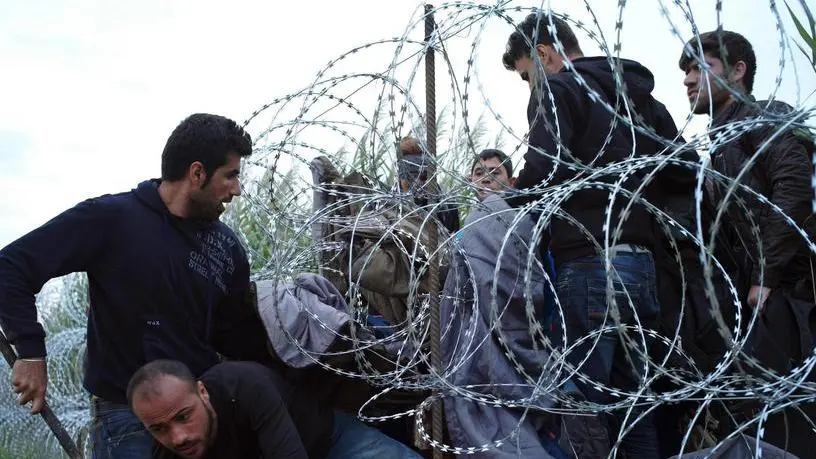 Profughi siriani al confine con l'Ungheria.ANSA/AP Photo/Bela Szandelszky)