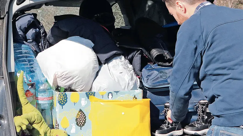 All’ex valico confinario di Fernetti un uomo sistema i bagagli nell’auto a bordo della quale ha lasciato l’Ucraina con la sua famiglia. Massimo Silvano